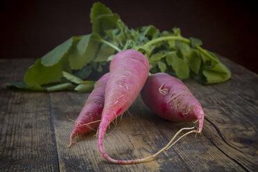 Organic red radish on dark wood, close-up - LVF004565