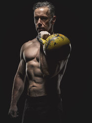 Porträt eines reifen Crossfit-Sportlers, der eine Kettlebell hält - MADF000834