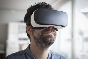 Lächelnder Mann mit Virtual-Reality-Brille - RBF004089