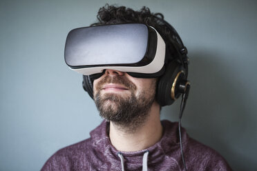 Mann mit Virtual-Reality-Brille und Kopfhörern - RBF004092