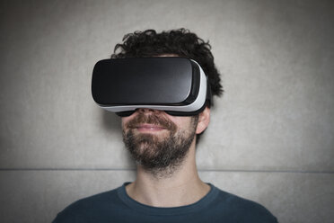 Lächelnder Mann mit Virtual-Reality-Brille - RBF004093
