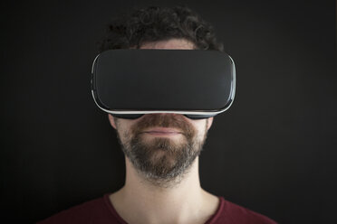 Mann mit Virtual-Reality-Brille vor schwarzem Hintergrund - RBF004096