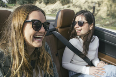 Zwei Frauen mit Sonnenbrillen lachen in einem Cabrio - ABZF000215