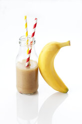 Glasflasche mit Bananensmoothie und eine Banane - CSF027239