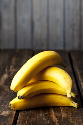 Pile of four bananas on wood - CSF027243