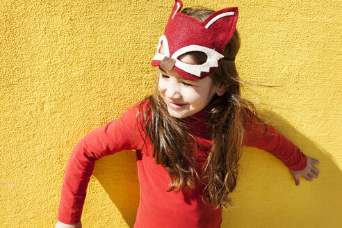 Porträt eines kleinen Mädchens mit Tiermaske vor einer gelben Wand - VABF000212