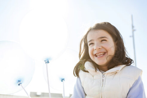 Porträt eines glücklichen kleinen Mädchens mit drei transparenten Luftballons - VABF000222