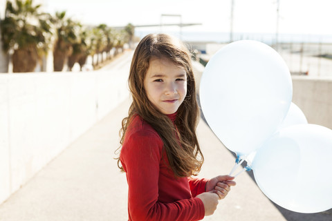 Portrait of little girl with three balloons stock photo