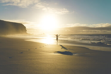 Woman at the beach running to the water at sunset - GEMF000758