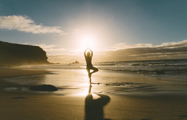 Frau übt Yoga am Strand bei Sonnenuntergang - GEMF000759