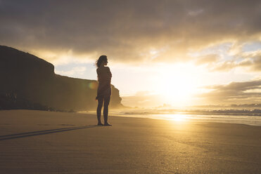 Woman standing on the beach at sunset - GEMF000763