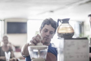 Mann arbeitet in einem Café und bereitet Kaffee zu - ZEF008550
