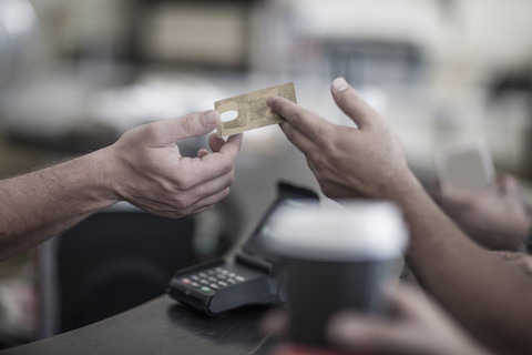 Mit Kreditkarte zahlende Person in einem Café, lizenzfreies Stockfoto