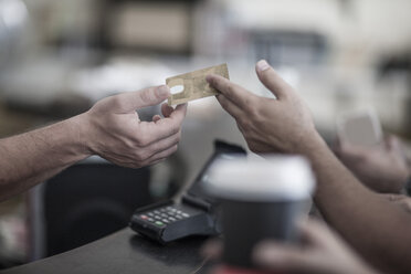 Person paying with credit card at coffee shop - ZEF008556