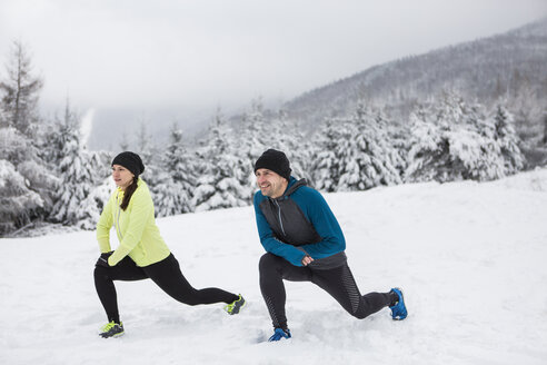 Ehepaar beim Aufwärmen für einen Langlauf im Winter - HAPF000243