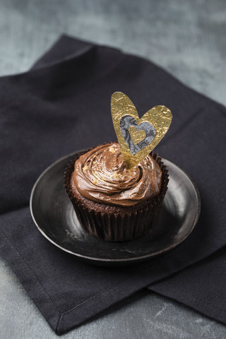 Cupcake mit Schokoladencreme und Goldpuder, dekoriert, lizenzfreies Stockfoto