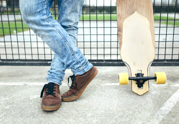 Legs of young man besides skateboard - MGOF001462