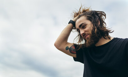 Portrait of bearded young man with tattoo on his upper arm - MGOF001471