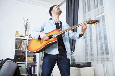 Young man at home playing guitar - SEGF000479