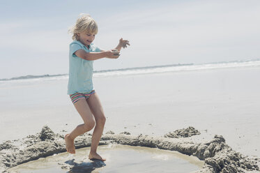 Frankreich, Bretagne, Finistere, Pointe de la Torche, Junge spielt mit Sand am Strand - MJF001790