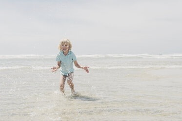 France, Brittany, Finistere, Pointe de la Torche, boy playing in water - MJF001792