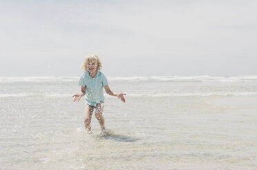 Frankreich, Bretagne, Finistere, Pointe de la Torche, Junge spielt im Wasser - MJF001792