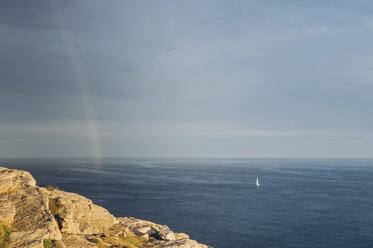 France, Brittany, Pointe du Raz, boat on the ocean with rainbow - MJF001800