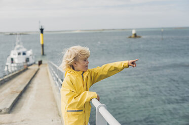 Frankreich, Bretagne, Roscoff, Junge am Hafen, der mit dem Finger zeigt - MJF001806