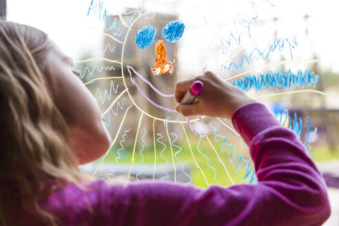 Mädchen malt Sonne auf Fensterscheibe - SARF002590
