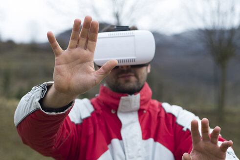 Mann spielt mit Virtual-Reality-Brille in der Natur - SKCF000074