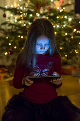 Mädchen mit Blick auf eine digitale Tafel zur Weihnachtszeit - SARF002597
