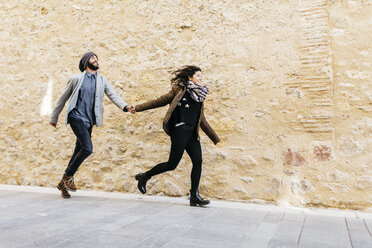 Spain, Tarragona, Young couple running - JRFF000461