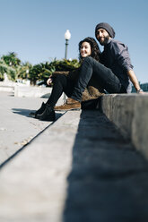 Spain, Tarragona, Young couple sitting on step - JRFF000468