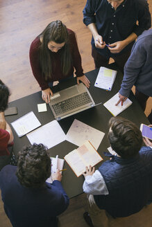 People with laptop and papers on a table during a work meeting - ABZF000225