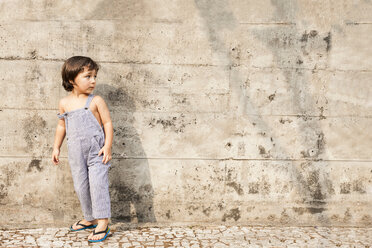 Kleiner Junge steht im Sommer vor einer Betonmauer - VABF000238