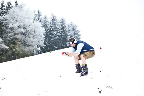 Mann trägt Virtual-Reality-Brille in Winterlandschaft und tut so, als würde er Ski fahren - MAEF011366