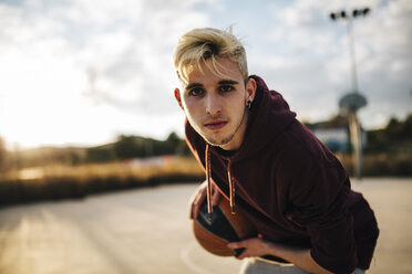 Porträt eines jungen Mannes, der auf einem Platz im Freien Basketball spielt - JRFF000493