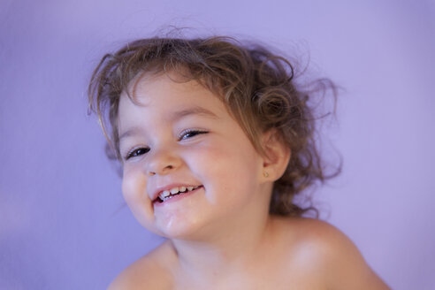 Portrait of smiling little girl in front of purple background - ERLF000145