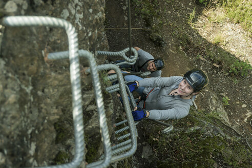 Germany, Westerwald, Hoelderstein, man and woman climbing on via ferrata - PAF001552