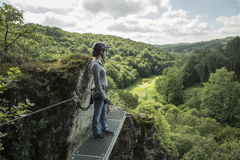 Deutschland, Westerwald, Hölderstein, Frau auf Klettersteig mit Blick auf Aussicht - PAF001555