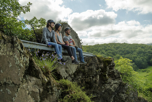 Deutschland, Westerwald, Hölderstein, drei Freunde auf dem Klettersteig machen eine Pause - PAF001556