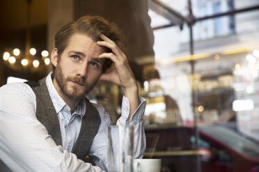 Young man in a cafe looking out of window - SUF000062