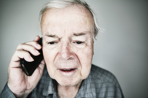 Porträt eines älteren Mannes, der mit einem Smartphone telefoniert - JATF000854