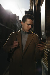 Man looking on cell phone in the city - BOYF000106