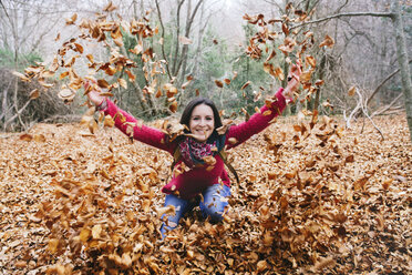 Woman throwing autumn leaves in the air - GEMF000767