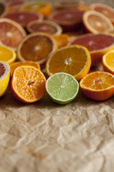 Halves of different citrus fruits on crumpled brown paper - VABF000258