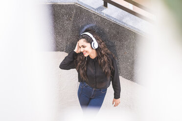 Smiling teenage girl listening music with headphones - SIPF000222