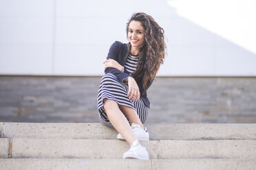 Portrait of smiling teenage girl sitting on steps - SIPF000227
