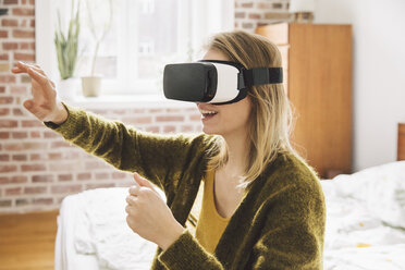 Woman wearing virtual reality glasses using her hands - MFF002743