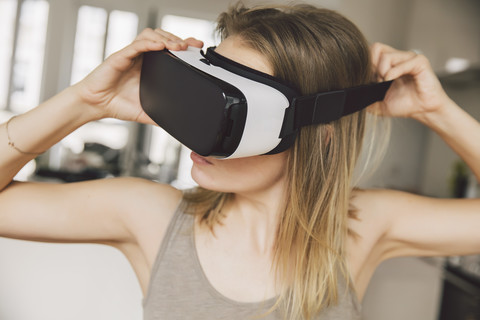 Frau setzt Virtual-Reality-Brille auf, lizenzfreies Stockfoto